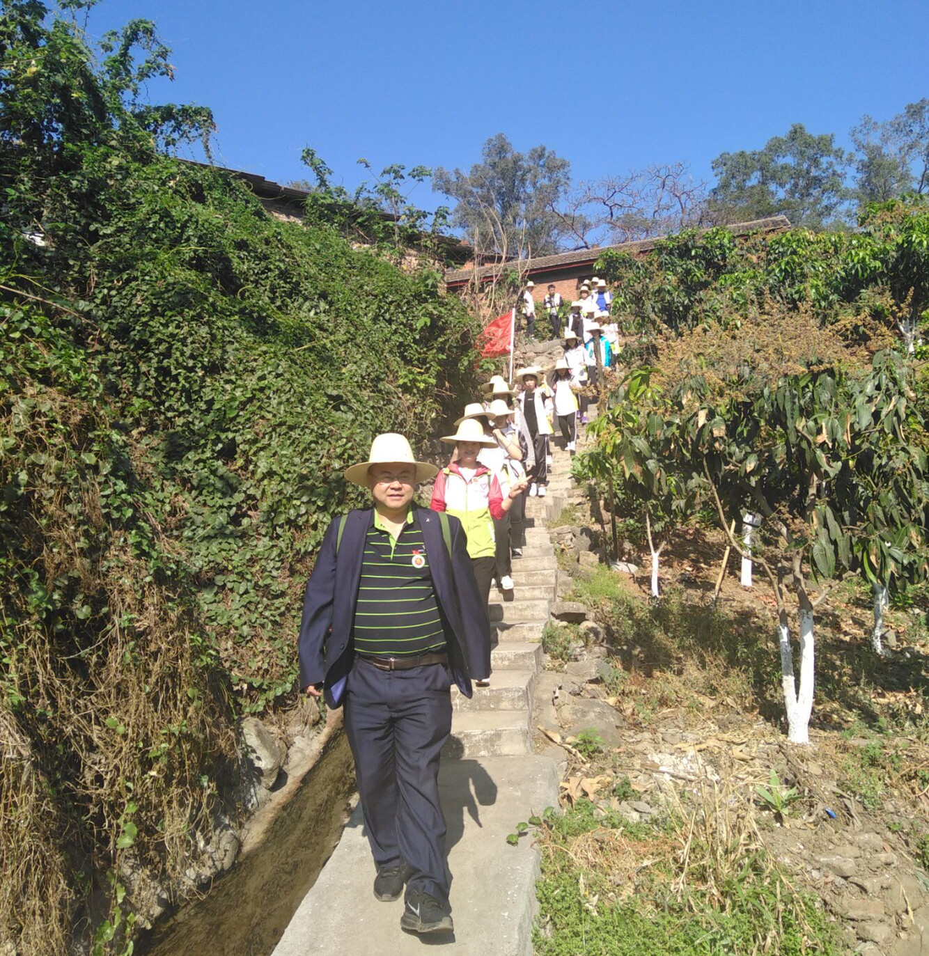 师生背水行走在山路上